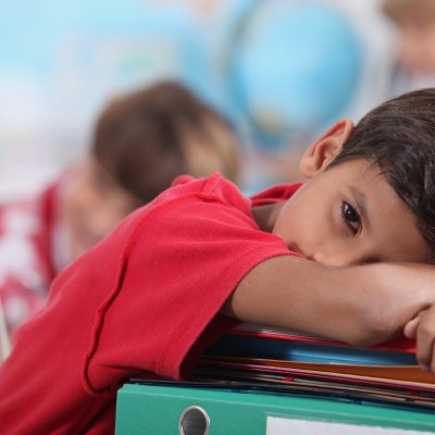 Young boy resting his head on books